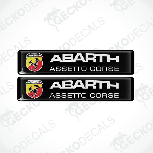 Two black rectangular vinyl decals with 'ABARTH ASSETTO CORSE' text and Abarth logo in red and yellow.
