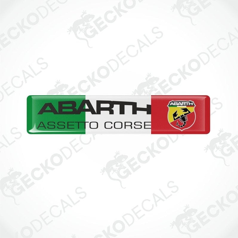 Vinyl stickers with polyurethane coating. One sticker is red with a yellow shield and the other is green with a black shield, both featuring the 'ABARTH ASSETTO CORSE' text and logos.