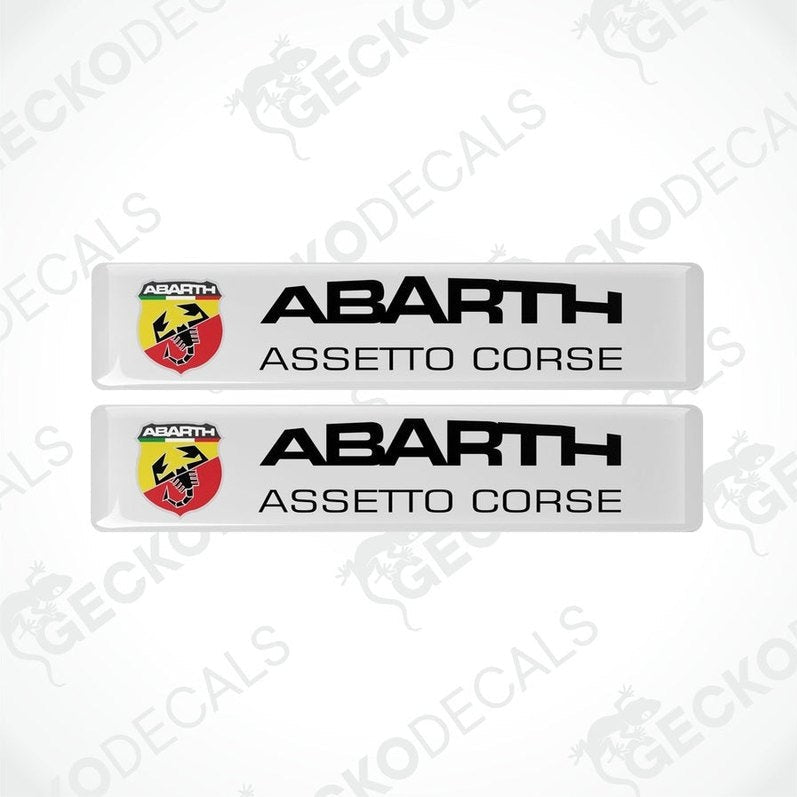 Two white rectangular vinyl decals with 'ABARTH ASSETTO CORSE' text and Abarth logo in red and yellow.