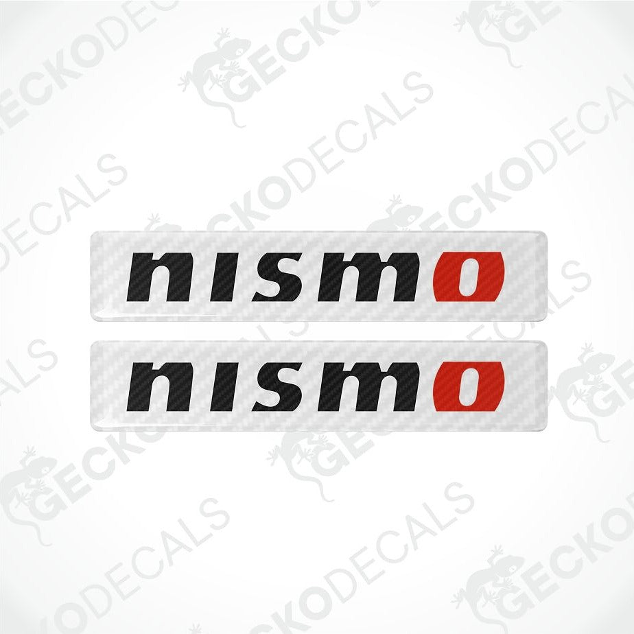 Two rectangular Nismo decal stickers with a carbon-fiber textured background, featuring the word 'nismo' in black with a red 'o' accent.
