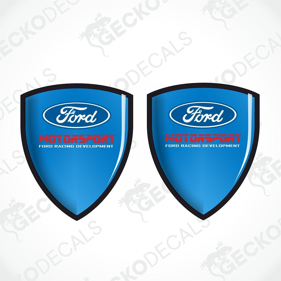 Two blue Ford shield-shaped decals with black borders, white Ford logos, and red and white text reading 'MOTODRIFT FORD RACING DEVELOPMENT' on a white background with faint GECKODECAL watermarks.
