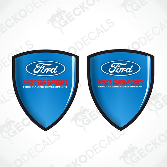 Two blue Ford shield-shaped decals with black borders, white Ford logos, and red and white text reading 'MOTODRIFT FORD RACING DEVELOPMENT' on a white background with faint GECKODECAL watermarks.