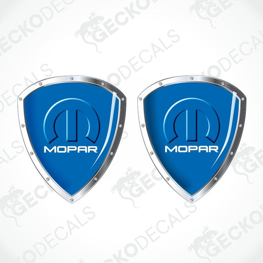Two blue shield-shaped Mopar decals with silver borders and the Mopar logo, shown on a light gray background with diagonal watermark text.