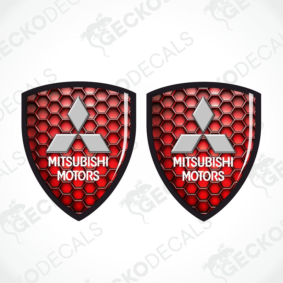 Two identical Mitsubishi Motors shield-shaped decals with a red honeycomb pattern, silver三菱 logo, and white text on a light gray background with diagonal watermarks.