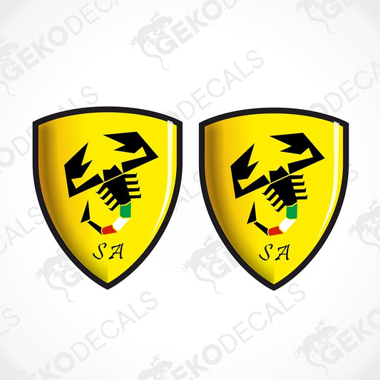 Two yellow Ferrari-style shield decals with a black scorpion logo, black border, and the letters 'SA' at the bottom, shown on a white background with faint watermark text.