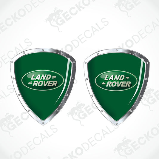 Two green Land Rover shield decals with silver borders and the Land Rover logo, shown on a white background with faint Geekodecals watermarks.