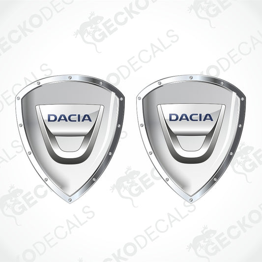 Two metallic silver Dacia shield-shaped decals with blue 'DACIA' lettering, shown on a light gray background with faint watermark text.