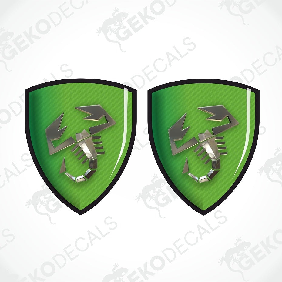 Two identical green shield-shaped decals with a black border and a metallic silver scorpion emblem, shown on a white background with diagonal watermark text.