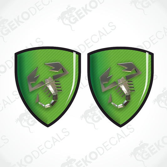 Two identical green shield-shaped decals with a black border and a metallic silver scorpion emblem, shown on a white background with diagonal watermark text.