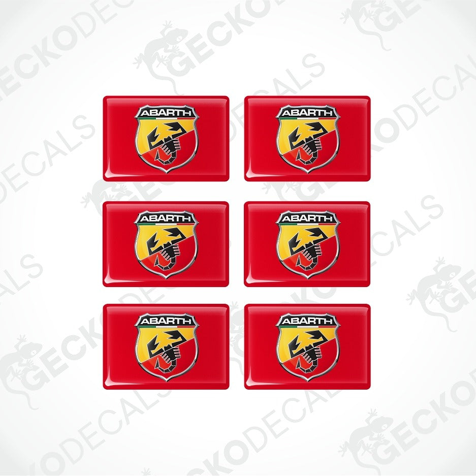 Six red rectangular decals arranged in a 3x2 grid on a white background, each featuring the Abarth logo with a yellow and black scorpion emblem.