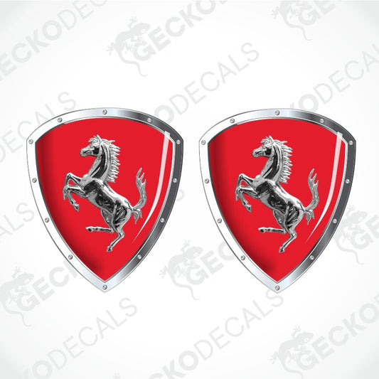 Two Ferrari prancing horse shield decals on a light gray background with diagonal watermarks. The decals feature a vibrant red background with a silver metallic border and the iconic silver horse emblem.