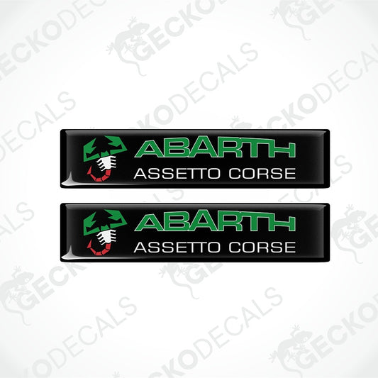 Two black rectangular car decals with the green and white Abarth Assetto Corse logo, displayed on a light gray background with diagonal watermarks.