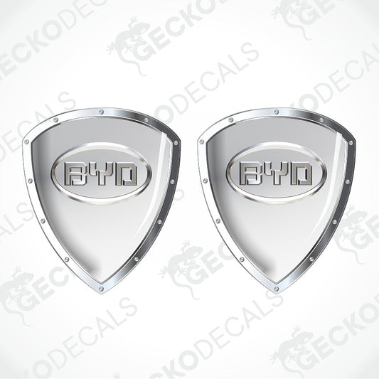 Two identical metallic silver shield-shaped decals with a central oval logo reading BYD, shown on a light gray background with repeated watermark text.