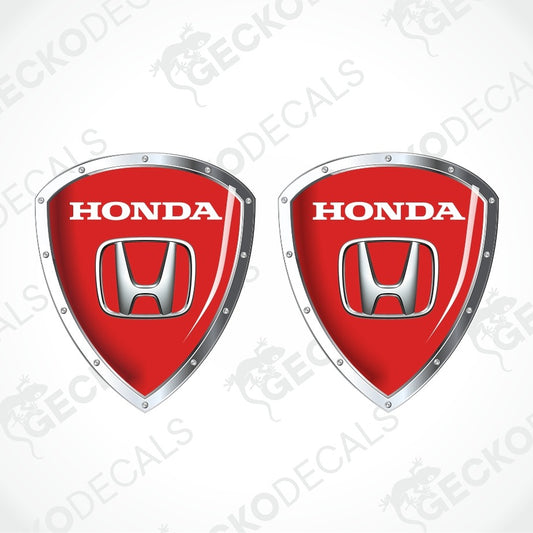 Two red Honda shield-shaped decals with silver metallic borders and the white HONDA wordmark and Honda logo on each, shown on a light gray background with repeated GECKODEC watermarks.