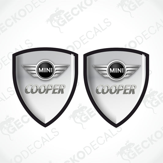 Two identical MINI Cooper shield-shaped decal designs on a light gray background with diagonal watermark text.