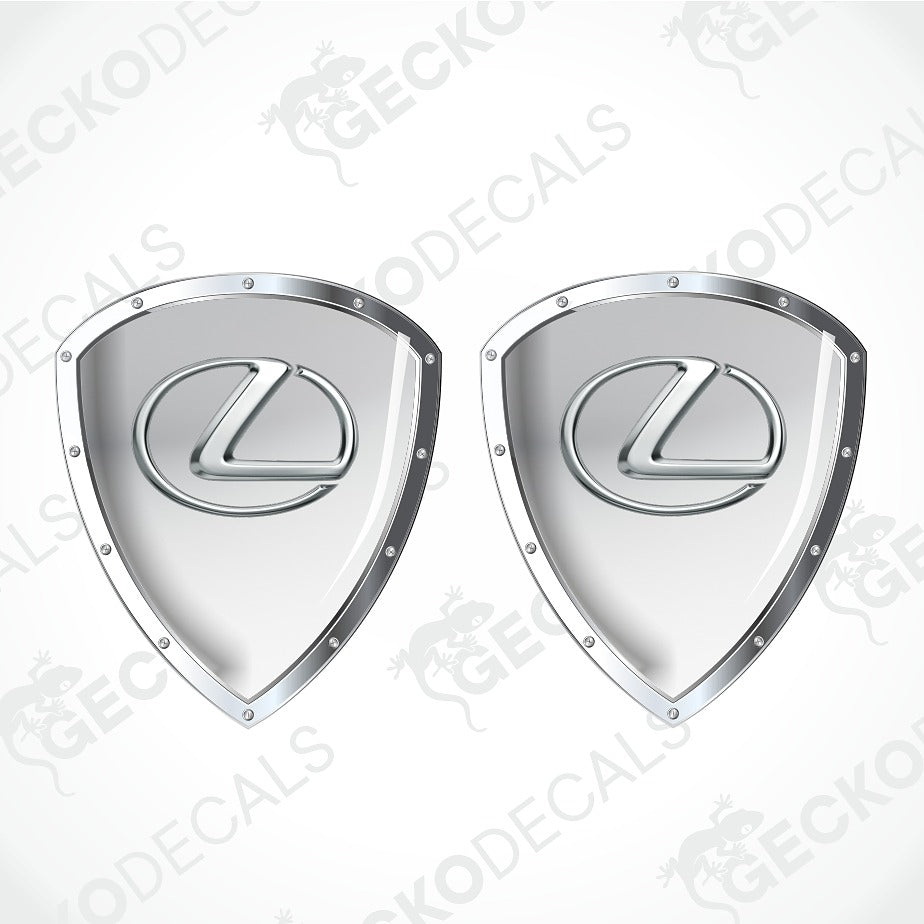 Two silver Lexus shield-shaped decals with the brand's logo in the center, shown on a light gray background with diagonal watermark text.