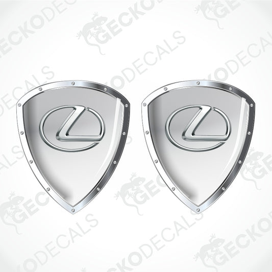Two silver Lexus shield-shaped decals with the brand's logo in the center, shown on a light gray background with diagonal watermark text.