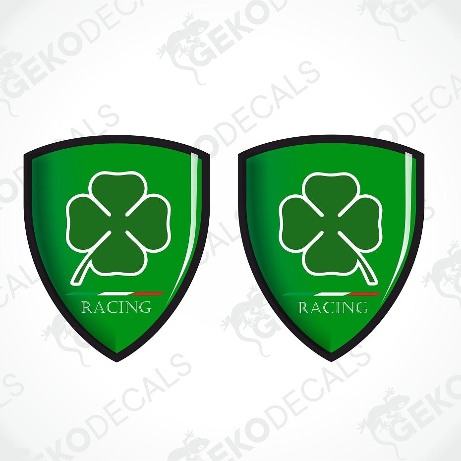 Two green shield-shaped decals with a white shamrock, outlined in black, and the word 'RACING' at the bottom, shown on a light gray background with faint diagonal watermarks.