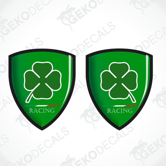 Two green shield-shaped decals with a white shamrock, outlined in black, and the word 'RACING' at the bottom, shown on a light gray background with faint diagonal watermarks.