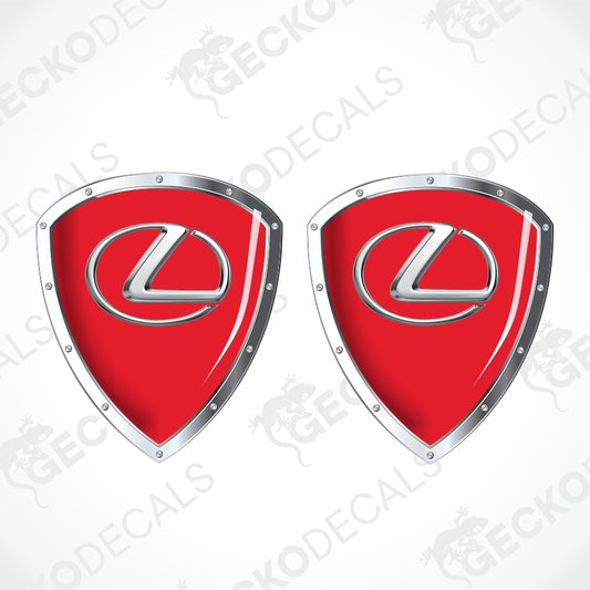 Two red shield-shaped Lexus decal stickers with silver metallic borders and the silver Lexus logo in the center, shown on a white background with a faint watermark pattern.