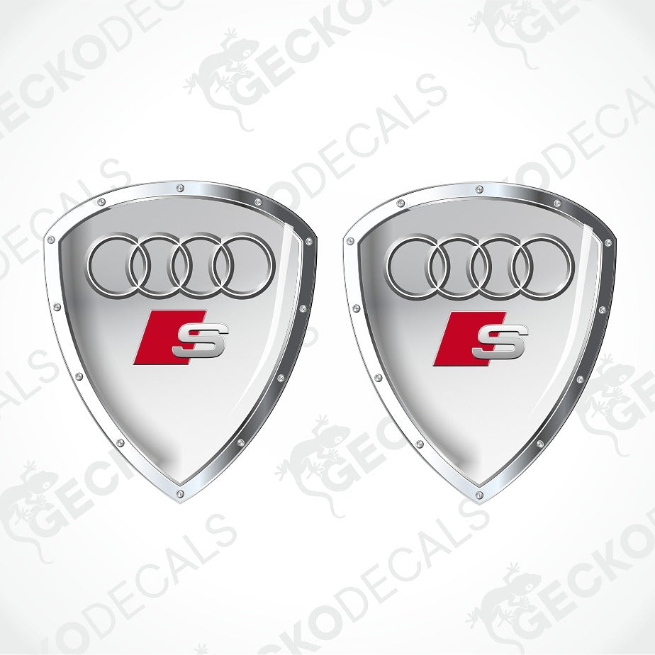Two silver Audi S shield-shaped decals with the four-ring logo and red S badge, shown on a white background with diagonal watermark text.