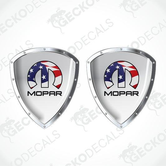 Two identical Mopar shield-shaped decals on a white background with diagonal watermarks. Each shield has a silver metallic border and a central graphic featuring a horseshoe with an American flag pattern (red, white, and blue with white stars) and the word 'MOPAR' in black below.