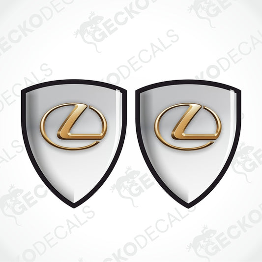 Two identical Lexus shield-shaped decals with a white center, black border, and a raised gold Lexus logo, shown on a light gray background with faint GECKODECALS watermarks.