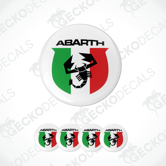 A circular white decal or badge featuring the word ABARTH above a green, white, and red shield with a black scorpion graphic, shown on a light gray background with four smaller identical badges along the bottom.