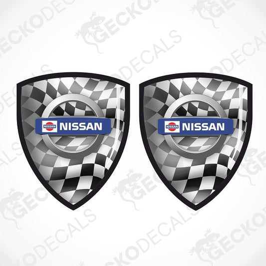Two identical Nissan shield-shaped decals with a black and white checkered pattern and a blue Nissan logo bar, shown on a light gray background with diagonal watermark text.