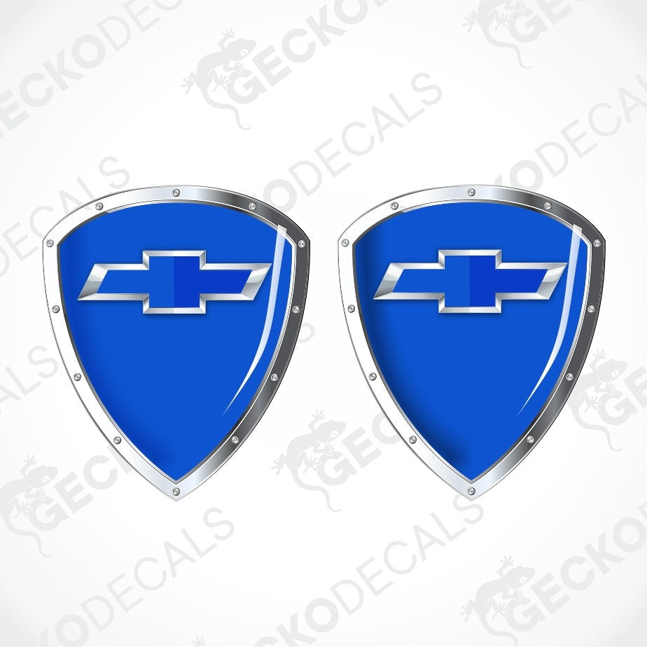 Two blue shield-shaped decals with silver metallic borders and the Chevrolet bowtie logo in the center, shown on a light gray background with faint GECKODECS watermarks.
