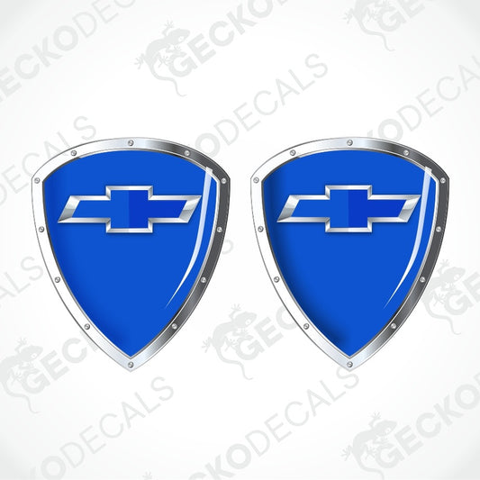 Two blue shield-shaped decals with silver metallic borders and the Chevrolet bowtie logo in the center, shown on a light gray background with faint GECKODECS watermarks.