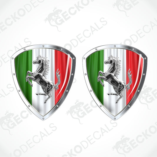 Two identical Ferrari-themed shield-shaped decals on a light gray background. Each shield features the Italian flag colors green, white, and red with a silver metallic border and a black prancing horse in the center.