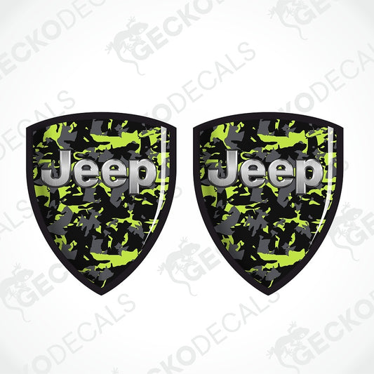 Two shield-shaped Jeep decals with a green, black, and gray camouflage pattern and silver 'Jeep' lettering, shown on a white background with diagonal watermarks.