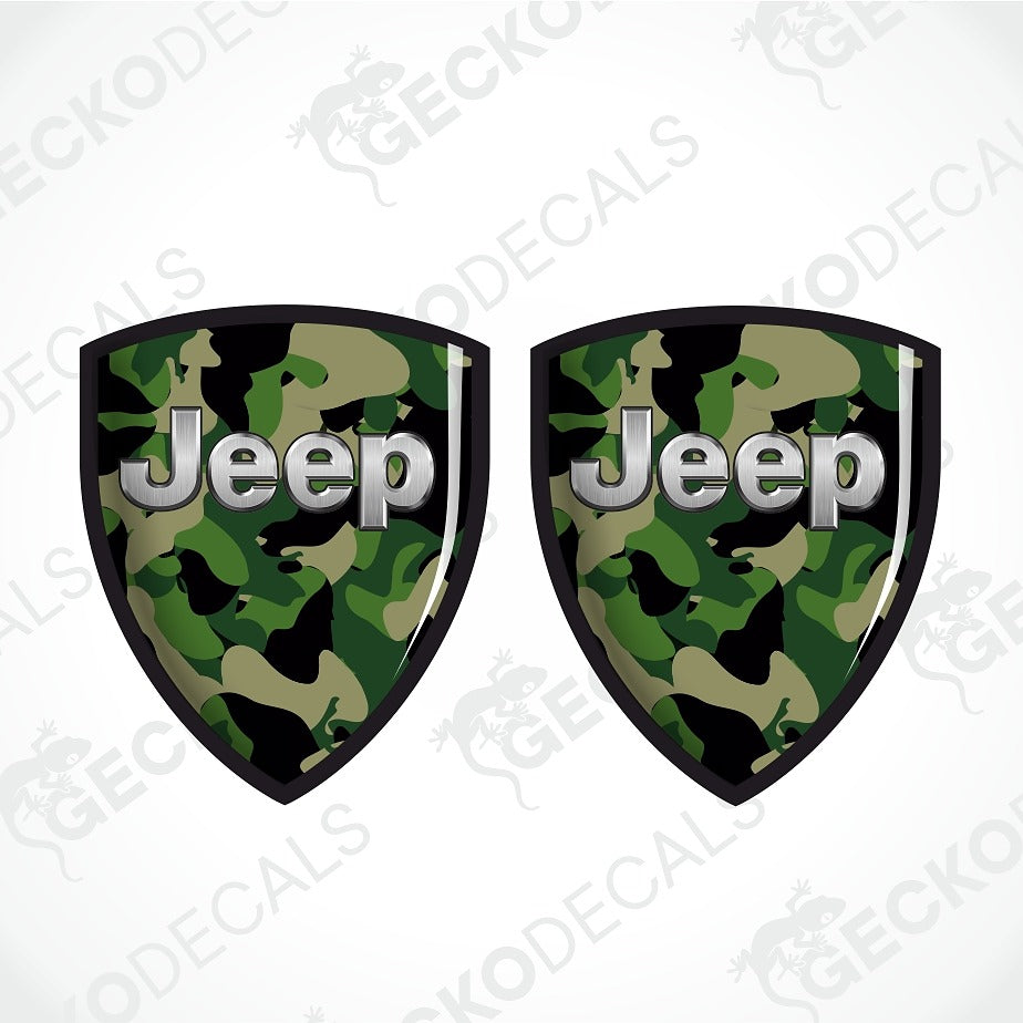 Two shield-shaped Jeep decals with a green and black camouflage pattern and silver 'Jeep' lettering, shown on a white background with diagonal watermarks.