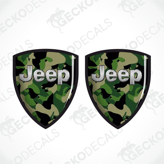 Two shield-shaped Jeep decals with a green and black camouflage pattern and silver 'Jeep' lettering, shown on a white background with diagonal watermarks.