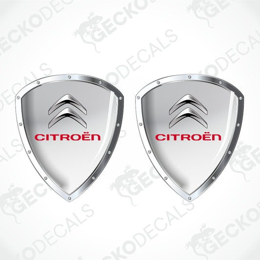 Two Citroèn shield-shaped decals with a metallic silver finish and the red Citroèn logo, shown on a light gray background with diagonal watermarks.