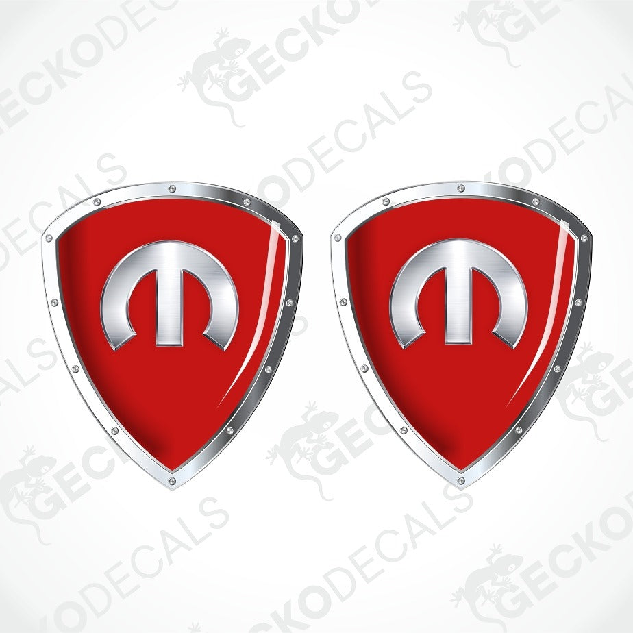 Two red shield-shaped decals with silver metallic borders and a silver emblem in the center, shown on a white background with a faint diagonal watermark pattern.