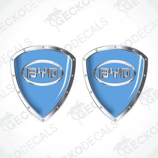Two identical blue shield-shaped decal designs with silver metallic borders and a central BYD logo, shown on a white background with faint diagonal watermark text.
