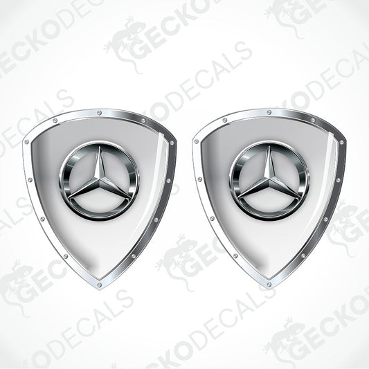 Two identical Mercedes-Benz shield-shaped decals with the three-pointed star logo, shown side by side on a light gray background with diagonal watermarks.