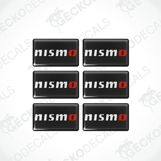 Six rectangular Nismo decal stickers arranged in a 2x3 grid on a white background. Each sticker has a black carbon fiber pattern background with the word 'nismo' in white and a red 'o'.