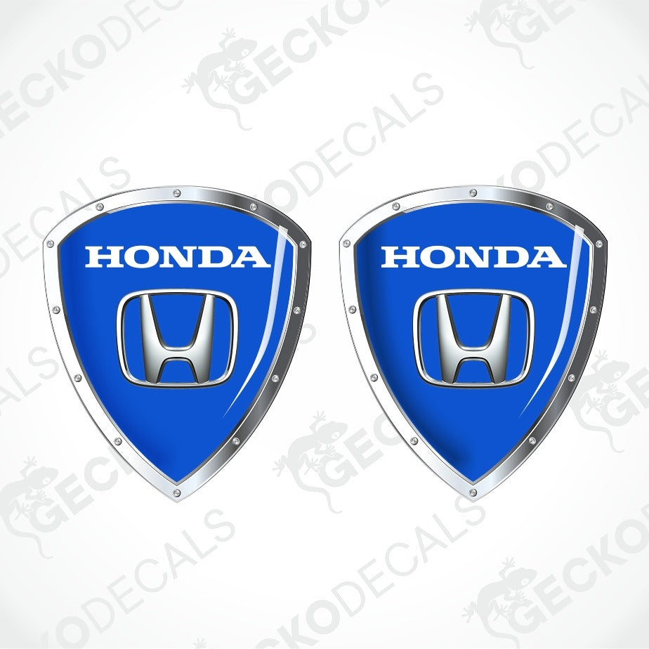 Two blue Honda shield-shaped decals with silver metallic borders and the white HONDA wordmark and logo, shown on a light gray background with repeated GECKODECALS watermark text.