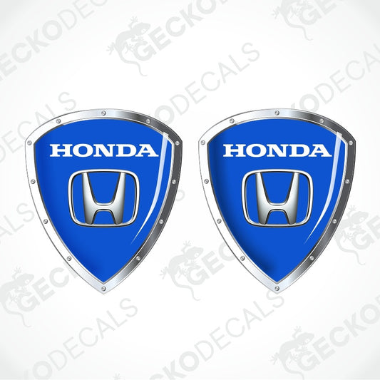 Two blue Honda shield-shaped decals with silver metallic borders and the white HONDA wordmark and logo, shown on a light gray background with repeated GECKODECALS watermark text.