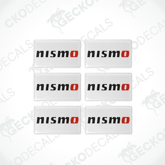 Six rectangular Nismo decal stickers arranged in a 2x3 grid on a white background with a faint watermark pattern. Each sticker has a carbon fiber texture, the word 'nismo' in black lowercase letters, and a red oval 'o' accent.