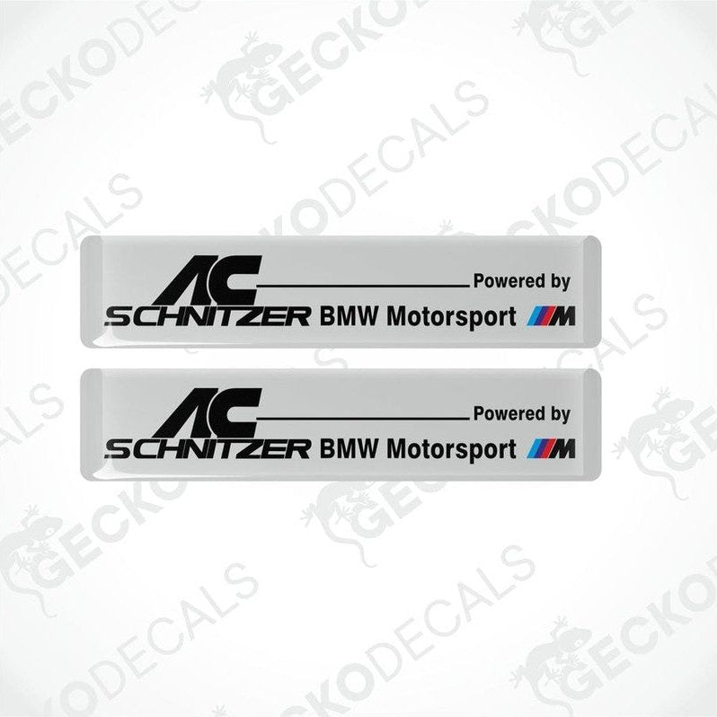 Two white vinyl decals with black text reading 'AC Schnitzer BMW Motorsport'.