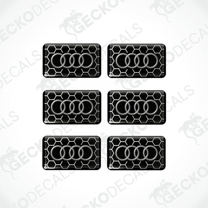 A set of six black vinyl stickers with a geometric pattern and the word 'Audi' printed on each.