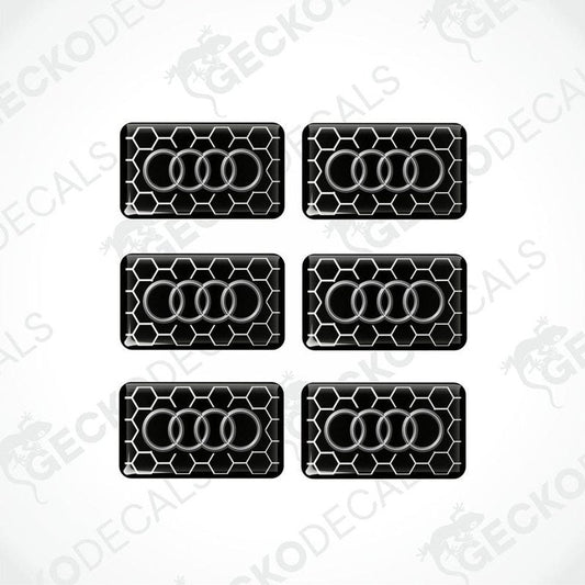 A set of six black vinyl stickers with a geometric pattern and the word 'Audi' printed on each.