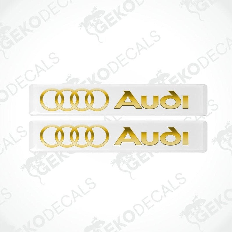 Two gold Audi decals on a white background with 'Gekodecals' branding.