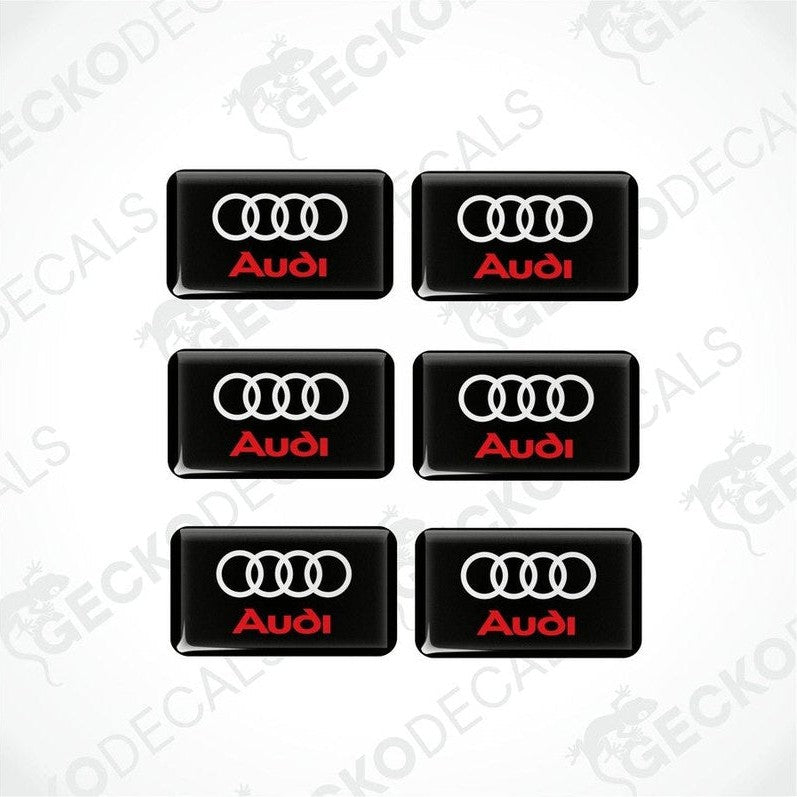 A set of six black vinyl stickers with a red and white Audi logo on each.