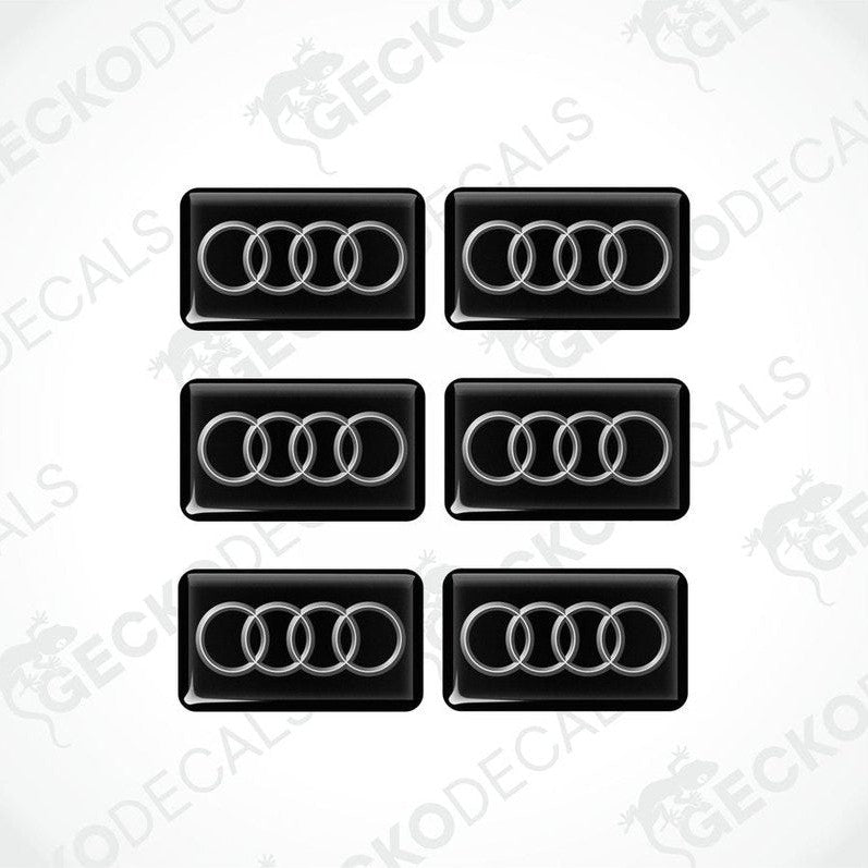 A set of six black and white vinyl decals with the Audi logo.