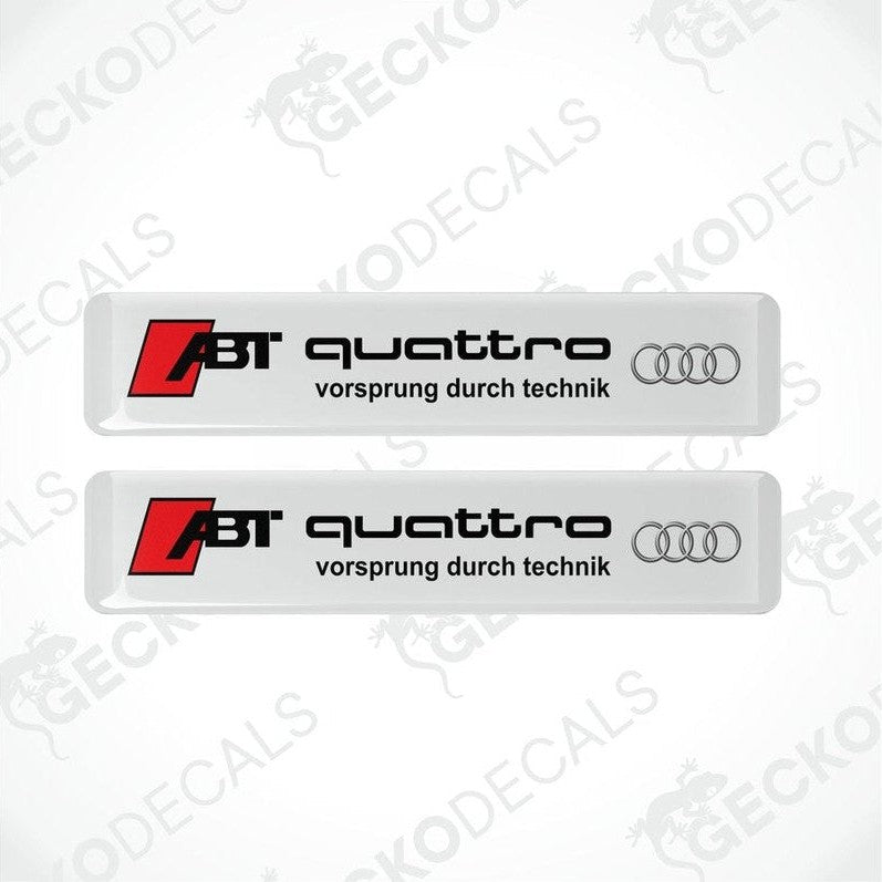 Two white vinyl stickers with the text 'ABT QUATTRO' and the Audi logo, with the slogan 'VORSPRUNG DURCH TECHNIK'.